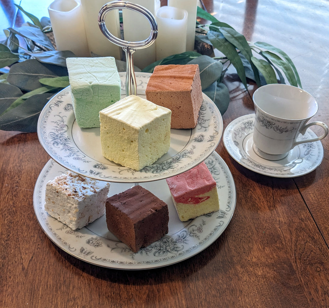 An enchanting two-tiered display, beautifully arranged with our top gourmet marshmallows. Each tier is brimming with fluffy, colorful marshmallows in a variety of delectable flavors. The elegant plate adds a touch of sophistication, making the presentation both visually stunning and irresistibly tasty.
