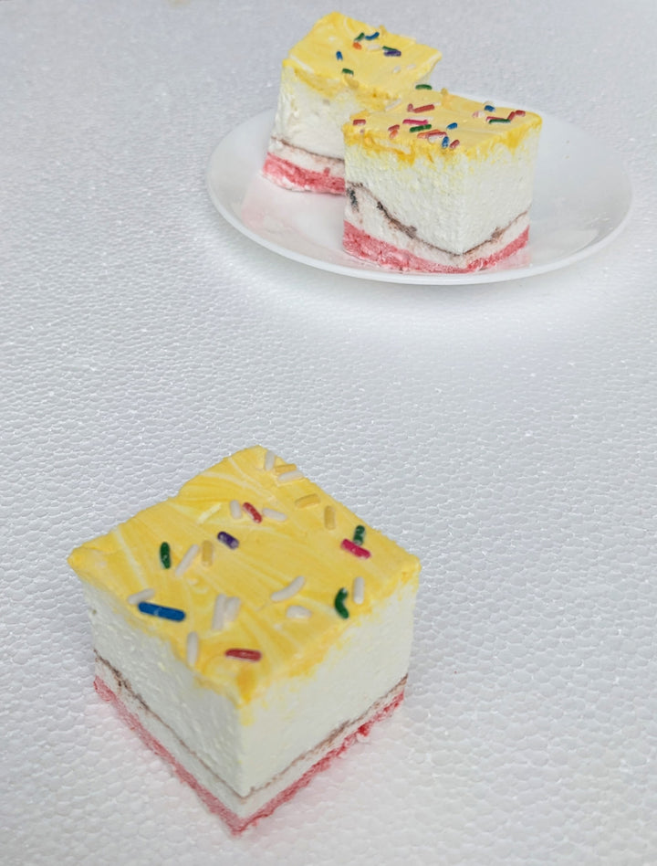A close-up of three banana split gourmet marshmallows, arranged with one marshmallow in the foreground and two slightly behind, creating a visually appealing depth against a clean white background. Each marshmallow is handcrafted in the USA, featuring swirls of yellow, red, and brown, embodying the classic banana, strawberry, and chocolate flavors. Adorned with vibrant sprinkles, these premium artisanal marshmallows boast a soft, pillowy texture—ideal for desserts, s’mores, gifting, and indulgent snacking.