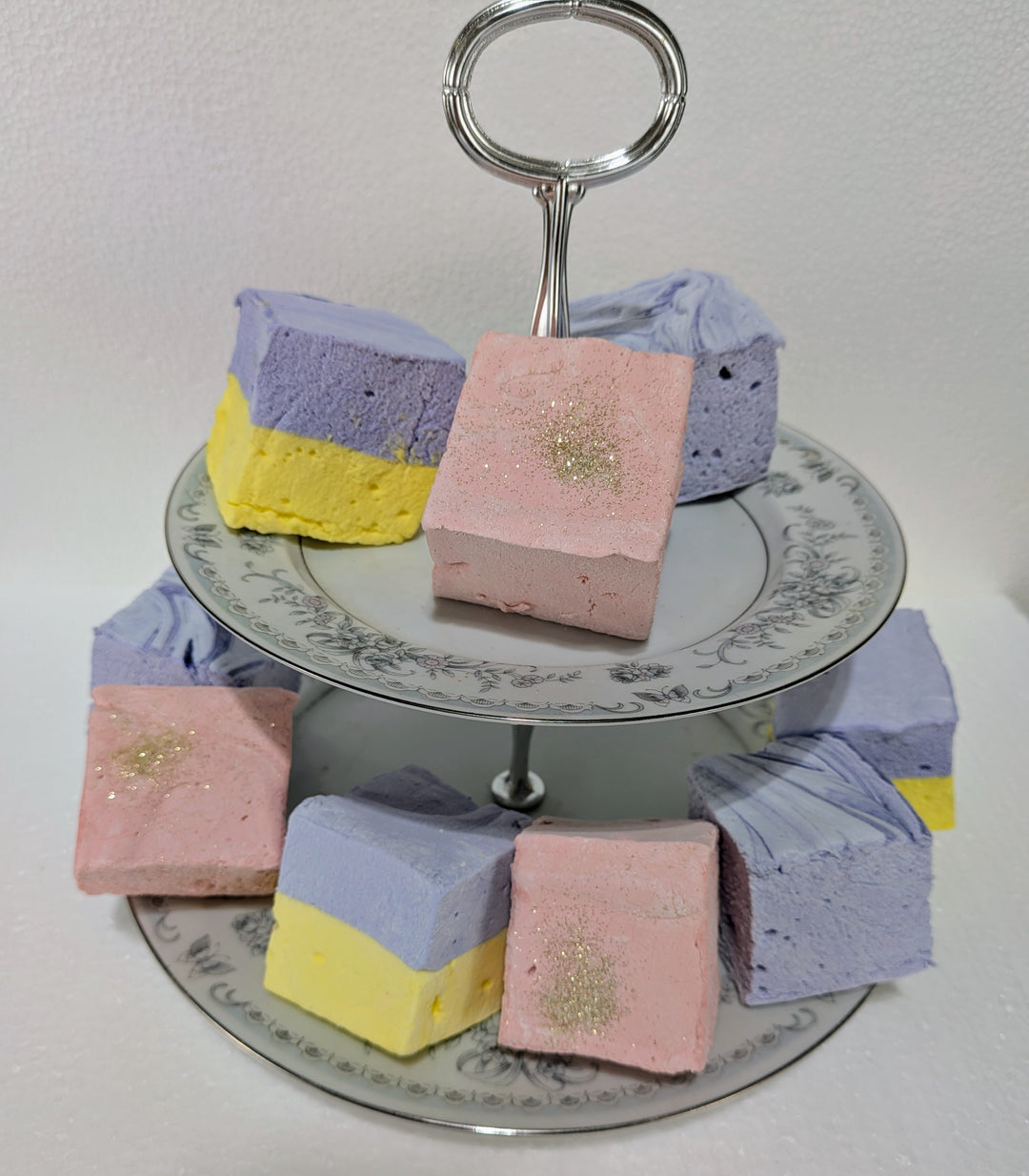 Pastel-colored layered Bougie Marshmallow Bundle on a decorative stand with a white background