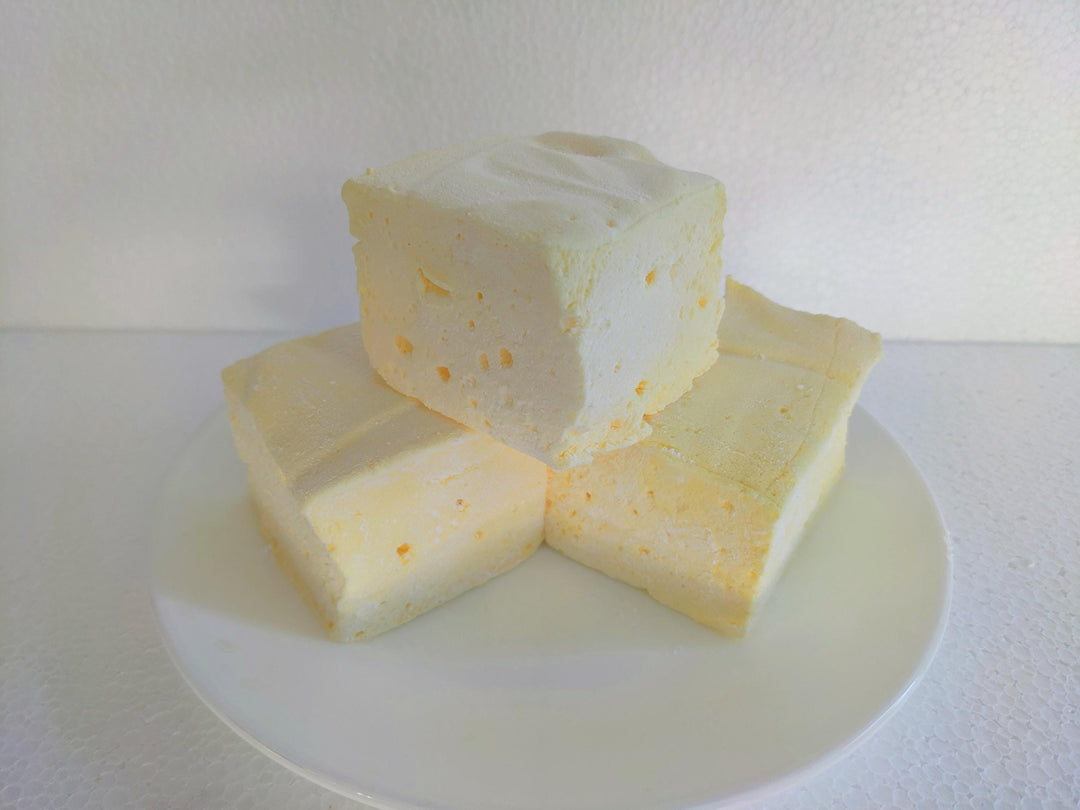 Three extra-large Butter Vanilla gourmet marshmallows made with organic marshmallow root and premium beef gelatin, displayed on a white plate against a plain white background.