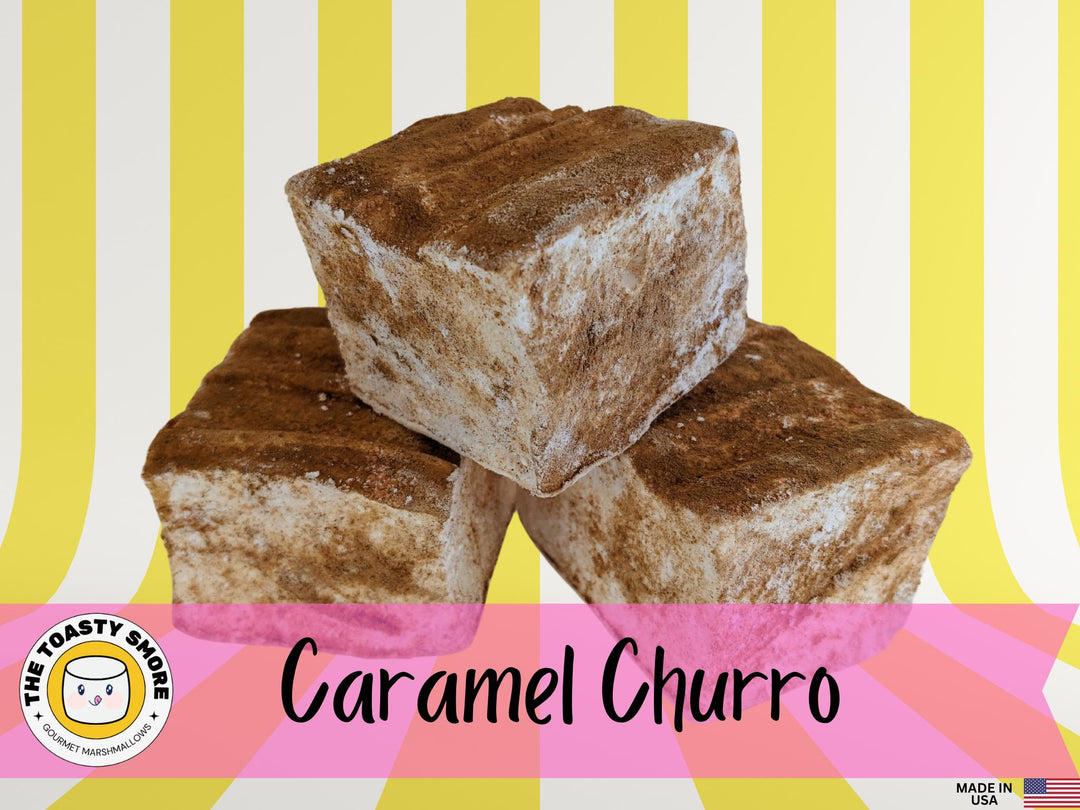 Three caramel churro marshmallows on a white plate, displayed against a yellow and white striped background. The image features The Toasty Smore logo and a "Made in USA" flag.