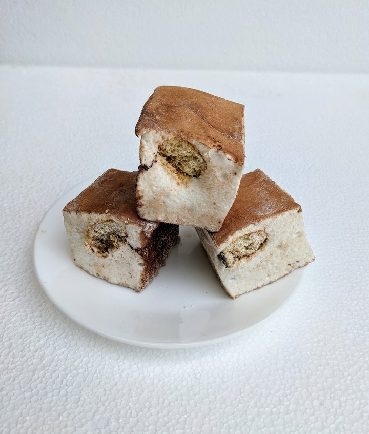 Indulgent tiramisu gourmet marshmallows—three handcrafted, espresso-infused delights dusted with rich cocoa powder—presented elegantly on a plate. These artisan marshmallows capture the essence of classic tiramisu with creamy mascarpone flavors, velvety texture, and a perfect balance of coffee and chocolate notes. A luxurious treat ideal for dessert lovers, specialty gifting, or pairing with coffee for a decadent experience.