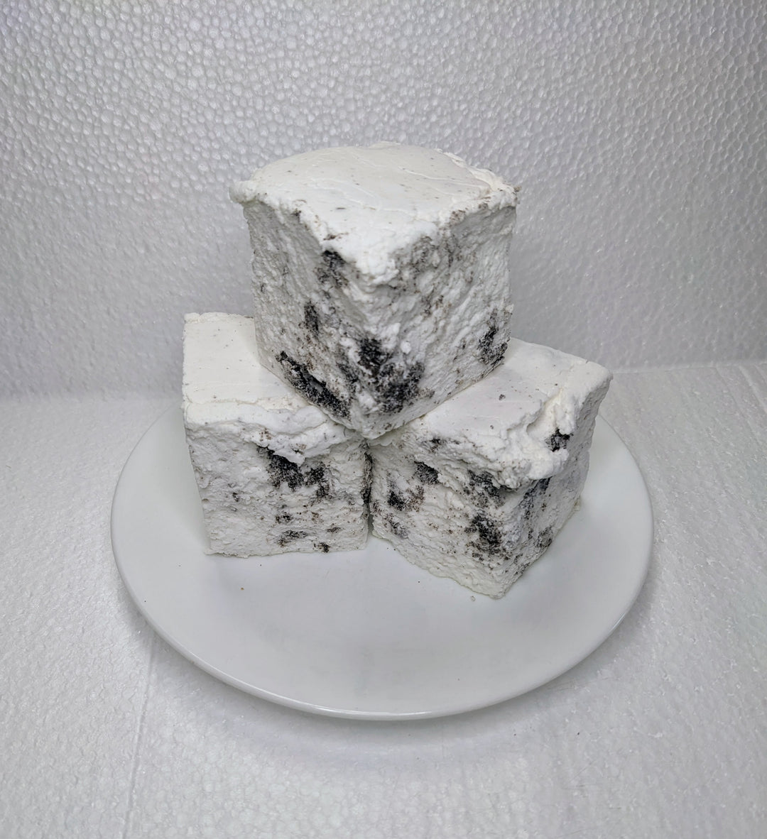 Three handcrafted gourmet cookies & cream marshmallows on a white plate, displayed on a plain white background. The marshmallows are approximately 2" x 2" x 2 each and made from premium gelatin. The image features The Toasty Smore logo and a "Made in USA" flag.