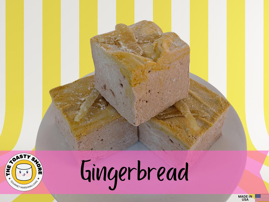 Three handcrafted gourmet gingerbread marshmallows, neatly placed on a white plate and displayed against a yellow and white striped background. Each marshmallow is approximately 2" x 2" x 1.5", crafted with high-quality beef gelatin. The image prominently features The Toasty Smore logo and a "Made in USA" flag.