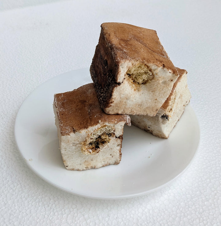 Three handcrafted tiramisu marshmallows, each infused with bold espresso flavors and coated in a fine dusting of premium cocoa powder. Their soft, pillowy texture and rich coffee essence make them a perfect gourmet dessert for indulgent snacking, luxury gifting, or pairing with a warm drink.