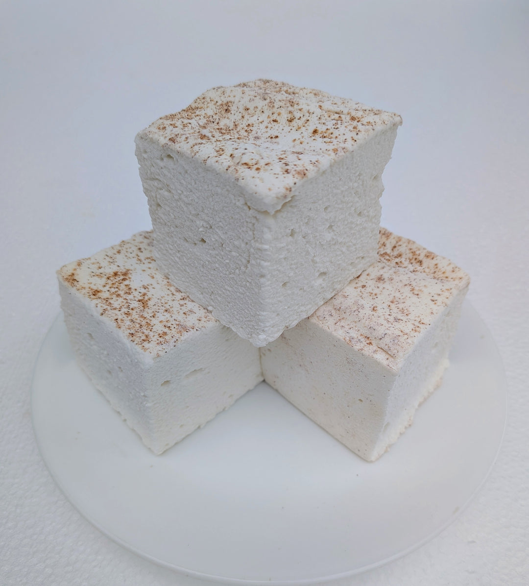 A trio of handmade horchata marshmallows showing natural creamy color and cinnamon dusting, crafted with beef gelatin and organic marshmallow root.