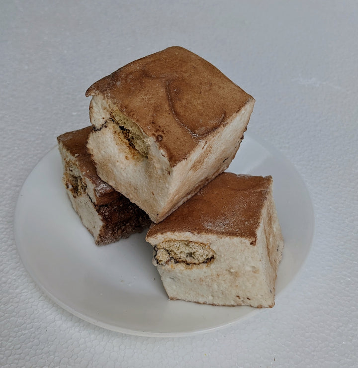 Three artisanal tiramisu marshmallows, hand-whipped to perfection, resting on a plate with a fine dusting of premium cocoa powder. Their velvety espresso-infused layers blend seamlessly with creamy mascarpone, offering a sophisticated dessert experience for gourmet connoisseurs and specialty treat lovers.