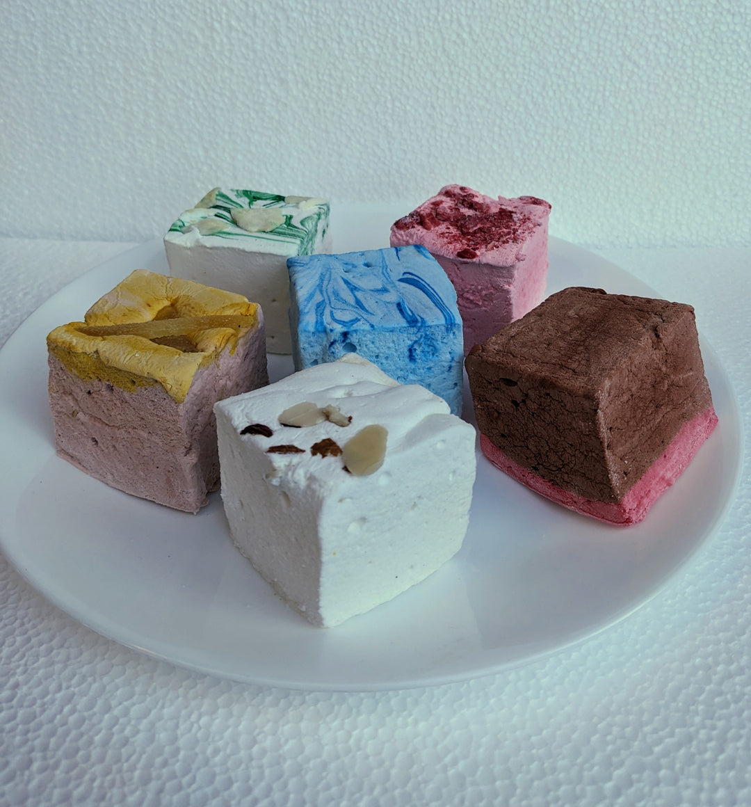 An enticing selection of our Medieval Delight Bundle marshmallows elegantly displayed on a two-tiered fancy plate. Featuring flavors like Red Rose Pudding, Gingerbread, Almond Cake, Junket with Blueberries, Pears in Wine Syrup, and Strawberries in White Custard Sauce