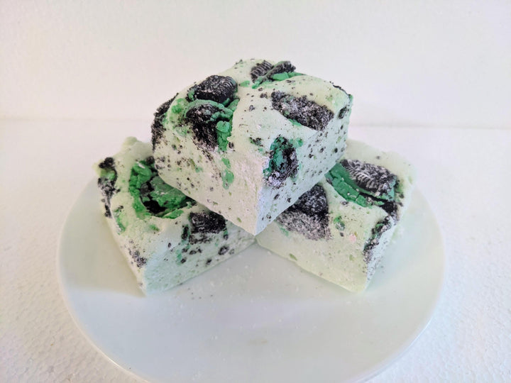 Three mint green marshmallows with Oreo crumbs on a plain white background.