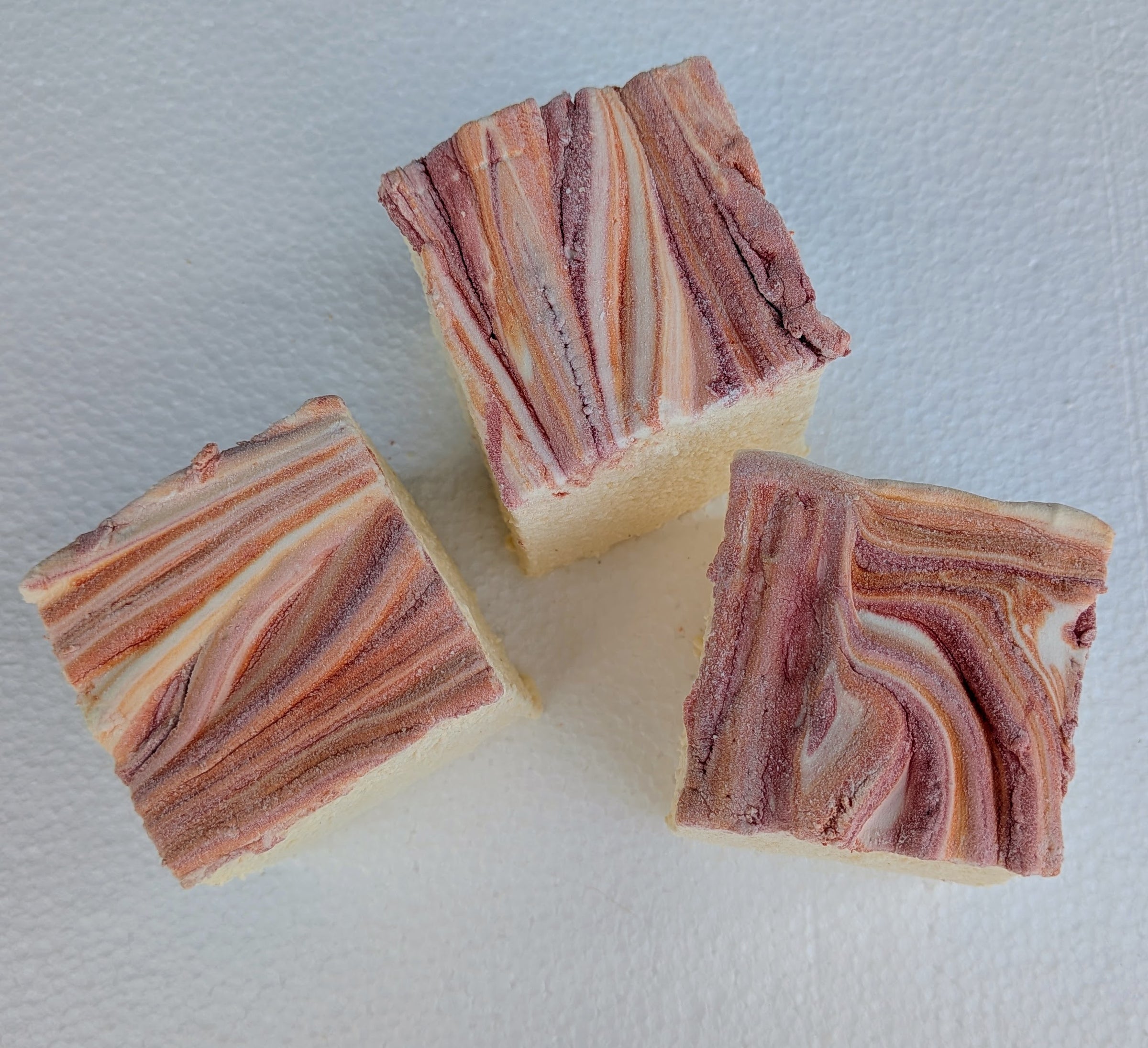 Yellow marshmallows finished with warm red and orange autumn swirls, made with cane sugar, invert syrup, beef gelatin, and organic marshmallow root for a seasonal gourmet flavor.