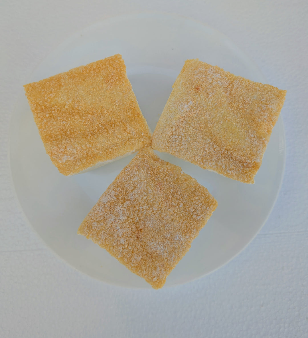 Three fluffy Piña Colada marshmallows with a light toasted top on a white plate, made with beef gelatin and organic marshmallow root; clean‑label, corn‑syrup free real marshmallows.