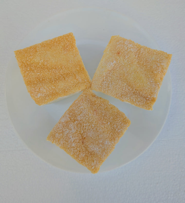 Three fluffy Piña Colada marshmallows with a light toasted top on a white plate, made with beef gelatin and organic marshmallow root; clean‑label, corn‑syrup free real marshmallows.