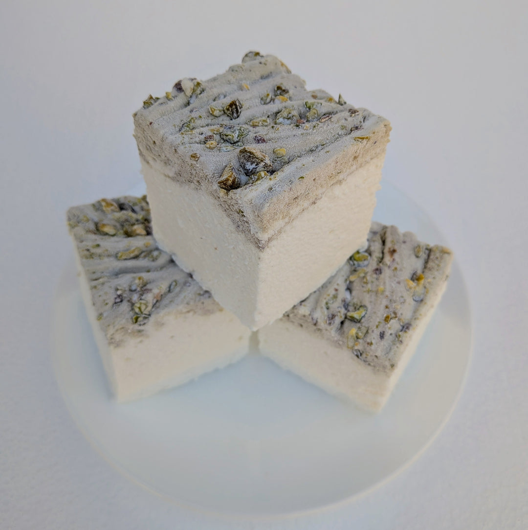 Three pistachio marshmallows made with beef gelatin and organic marshmallow root, stacked on a white plate with a ridged pistachio‑studded top. Clean‑label, gluten‑free, corn syrup‑free real marshmallows photographed in a close‑up food shot.