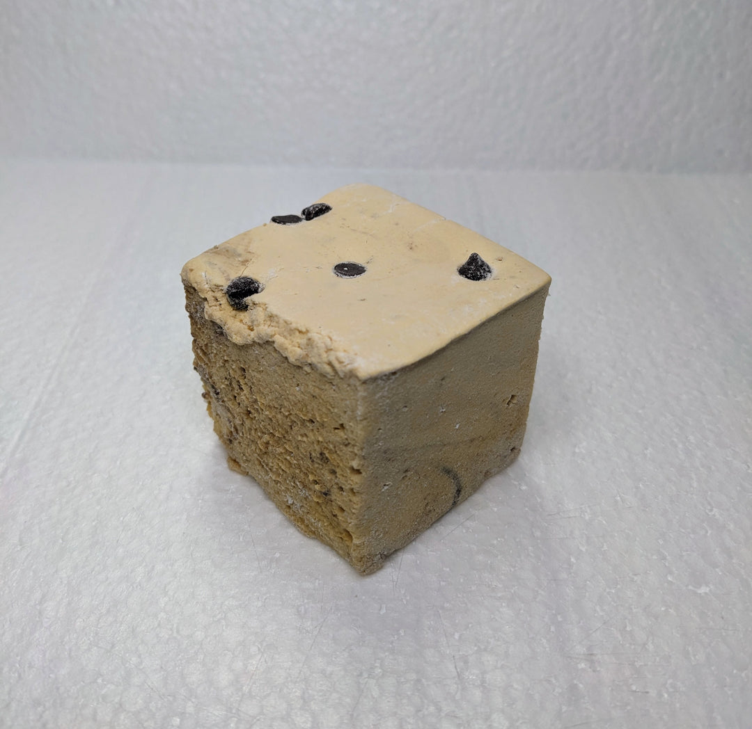 A single cookie dough marshmallow on a white plate, displayed on a clean, white background.