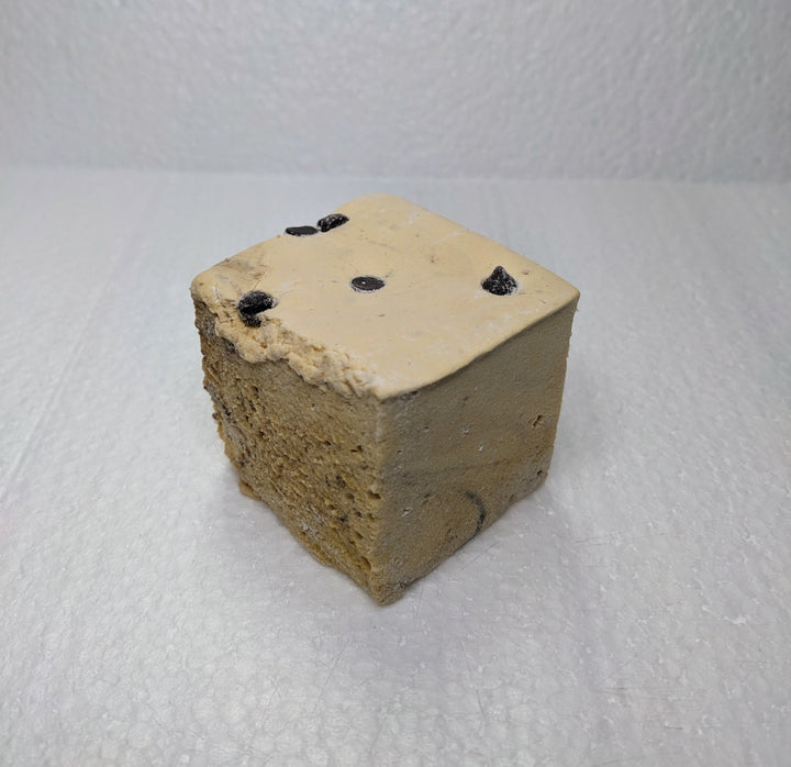 A single cookie dough marshmallow on a white plate, displayed on a clean, white background.