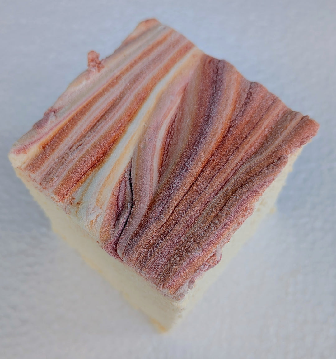 Pale yellow marshmallows featuring hand‑applied red and orange seasonal swirls, crafted in small batches using natural colors, artificial flavors, and gluten‑free corn starch.