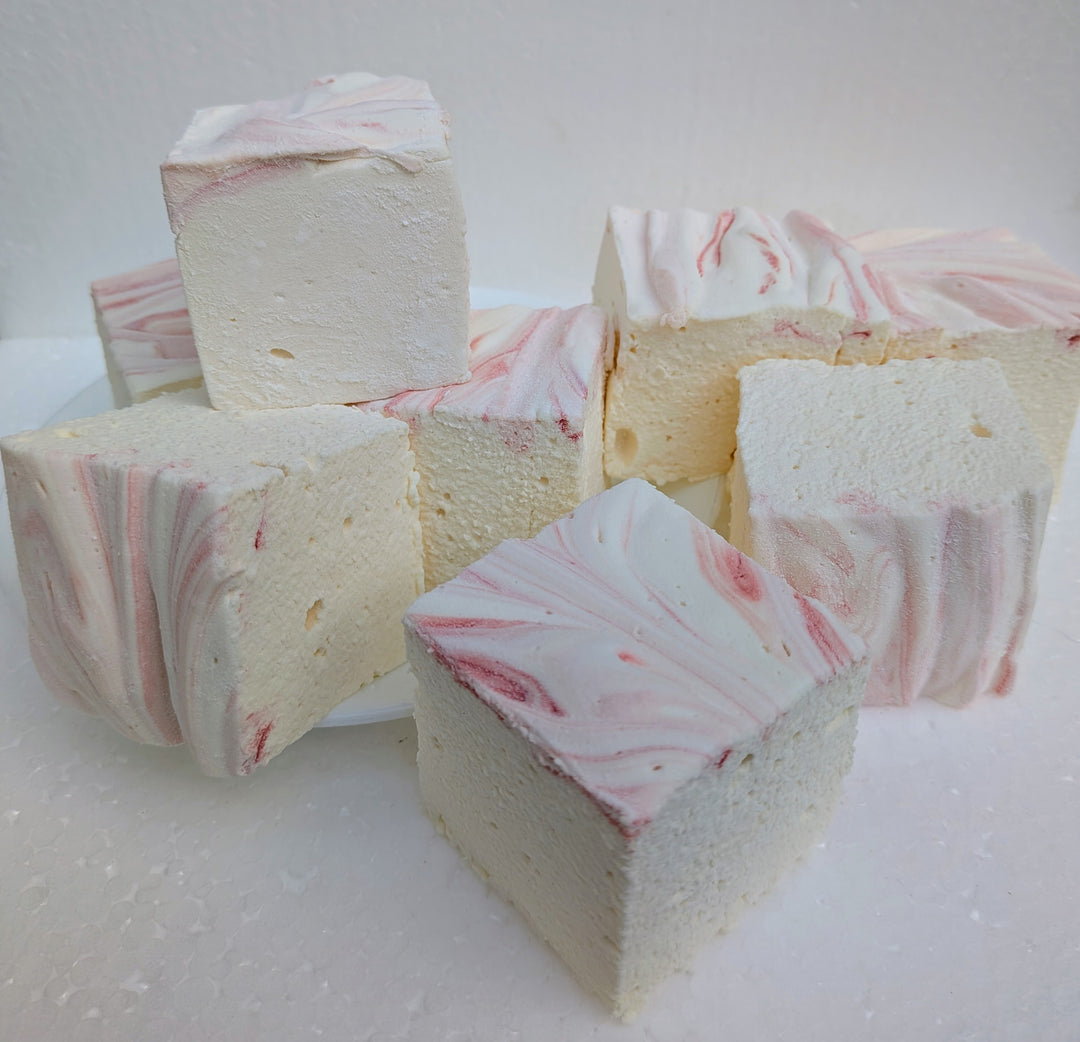 Strawberries and cream real marshmallows with natural pink and white swirls arranged on a white surface, handcrafted in the USA with Halal beef gelatin, organic marshmallow root, natural colors, and gluten‑free ingredients.