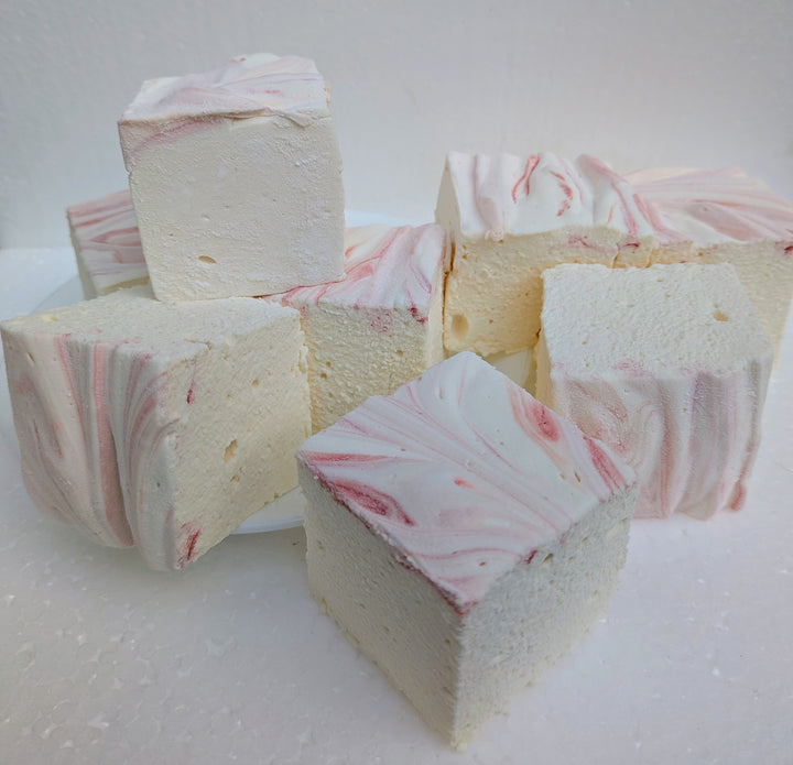 Strawberries and cream real marshmallows with natural pink and white swirls arranged on a white surface, handcrafted in the USA with Halal beef gelatin, organic marshmallow root, natural colors, and gluten‑free ingredients.