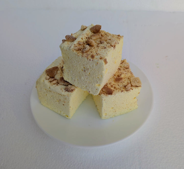 Three pieces of Banana Cream Pie gourmet marshmallows made with organic marshmallow root and premium beef gelatin, topped with crumb topping, on a white plate.