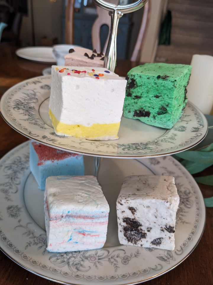 Another two-tiered plate featuring a vibrant assortment of birthday-themed marshmallows in flavors: birthday cake, cotton candy, blue raspberry, cookie dough, cookies & cream, and mint oreo.