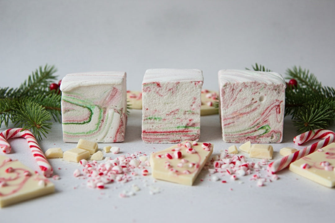 White Chocolate Peppermint Bark marshmallows by The Toasty S’more styled with crushed candy canes, white chocolate pieces, and festive Christmas greenery on a clean white background. Handcrafted with beef gelatin and organic marshmallow root for a corn-syrup free, clean-label holiday indulgence.