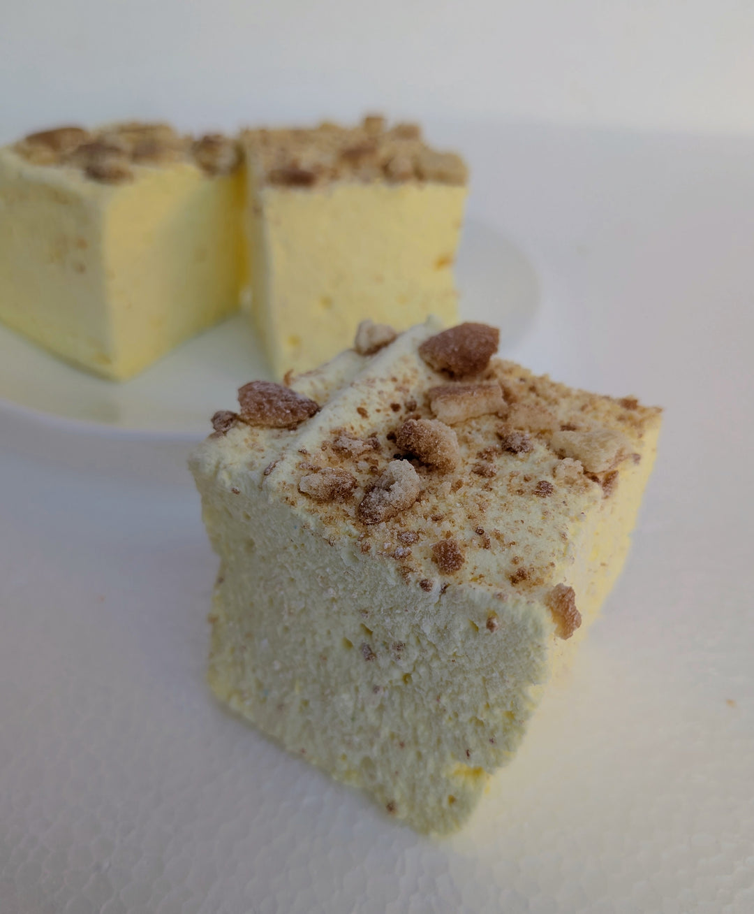 Banana Cream Pie gourmet marshmallows made with organic marshmallow root and premium beef gelatin, topped with a crumbly topping, displayed on a white surface.