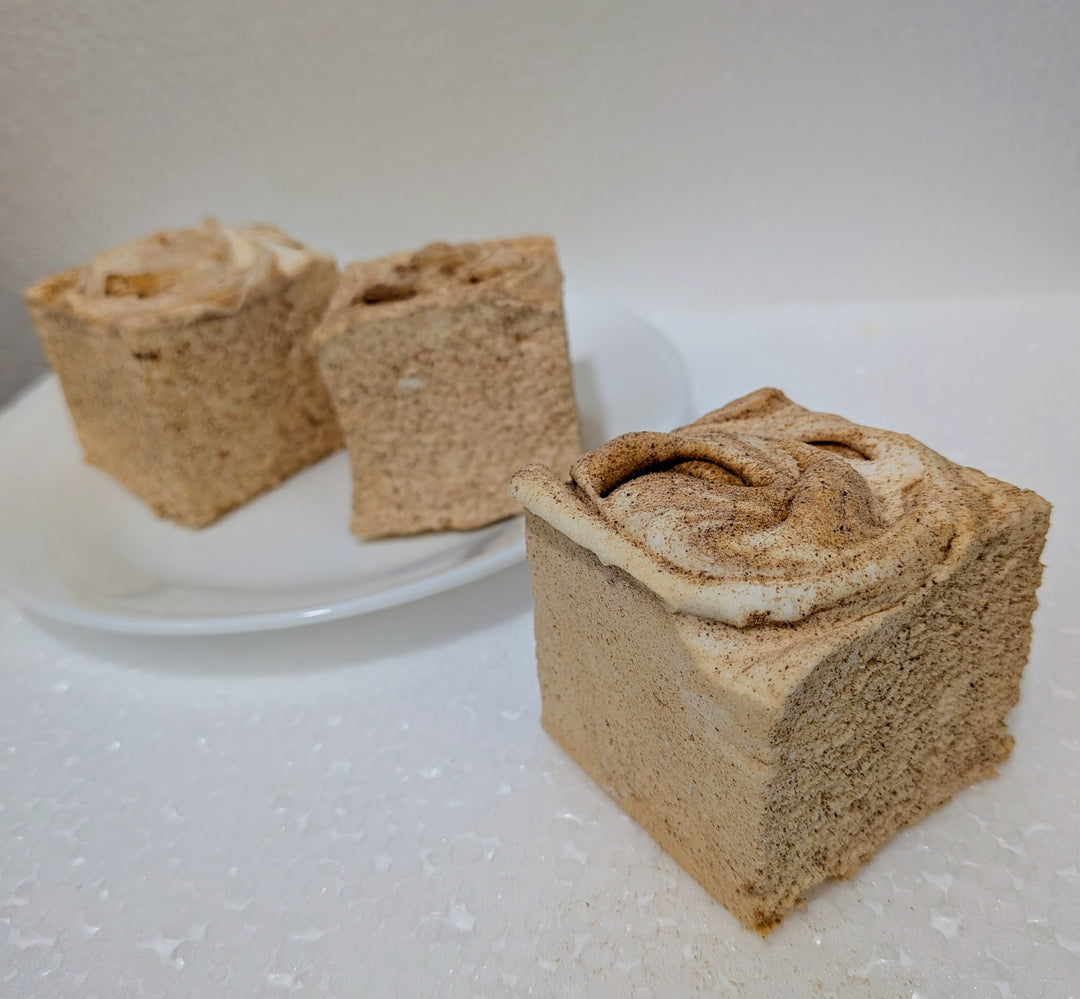 cinnamon roll gourmet marshmallows with a swirled filling on a white surface.