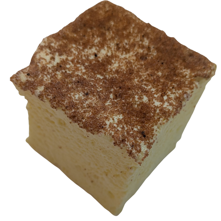 Square piece of creme brulee gourmet marshmallow with a brown crumbly topping on a white background