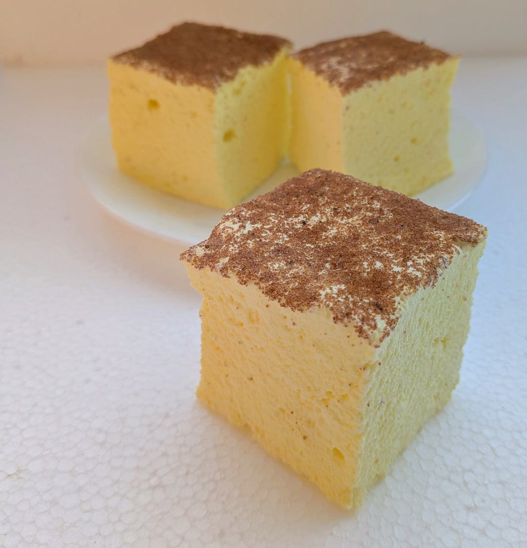 Three pieces of creme brulee gourmet marshmallow with brown crumb topping on a white surface
