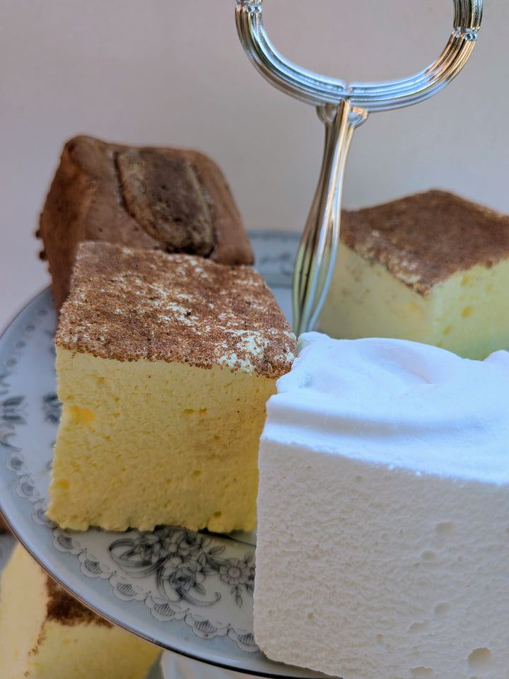 gourmet marshmallows with some various topping on a decorative cake stand.