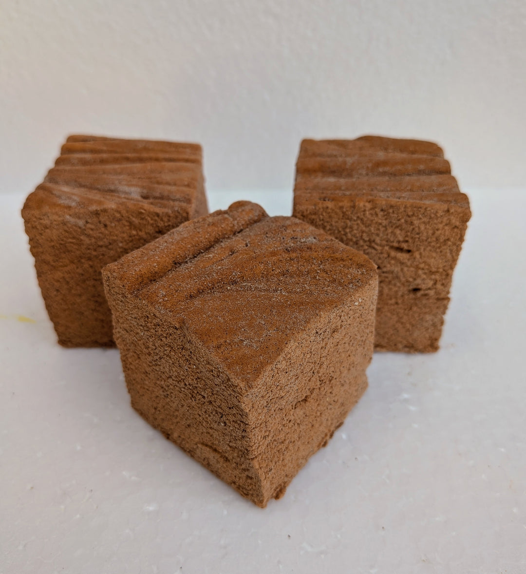 Three pumpkin spice gourmet marshmallows on a white background