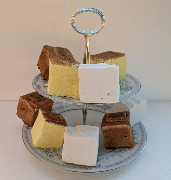 Three-tiered cake stand with square gourmet marshmallows on a light background