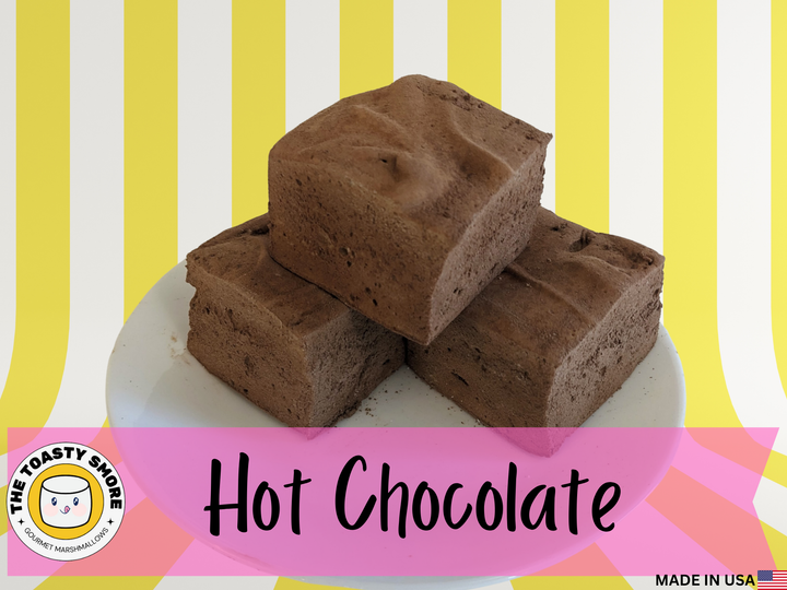 Three Hot chocolate marshmallows on a plate, displayed on a yellow and white striped background. The image features The Toasty Smore logo and a "Made in USA" flag