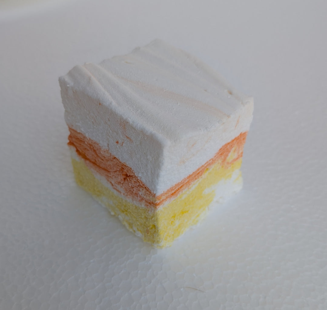 candy corn gourmet marshmallow with white, orange, and yellow colors on a white surface