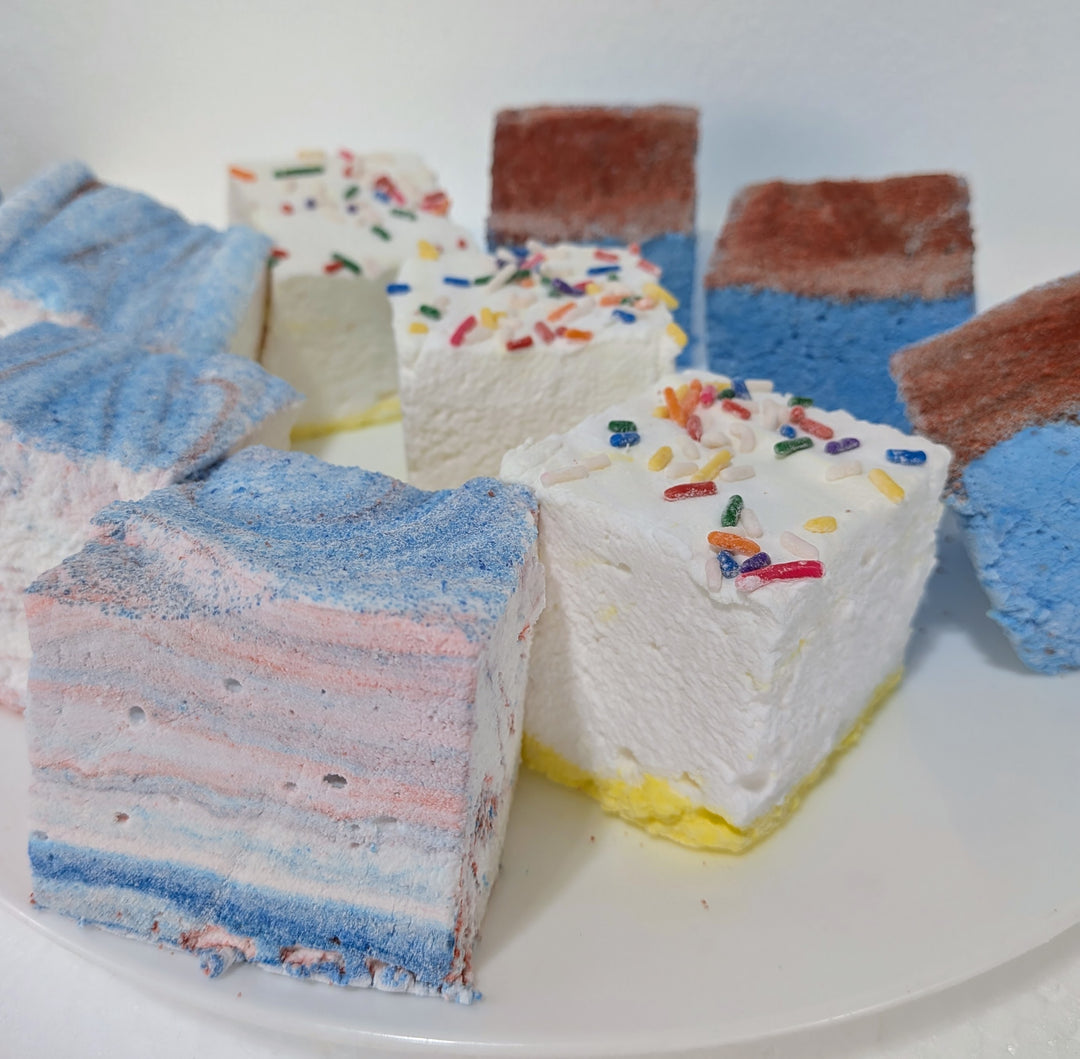 Colorful layered cake slices with sprinkles on a white plate