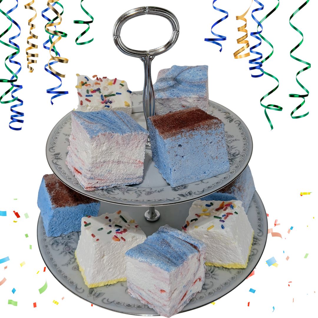 Three-layered cake stand with colorful gourmet marshmallows on a white background with confetti and streamers.