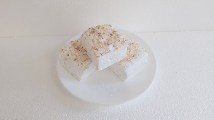 Handcrafted Gourmet Toasted Coconut Marshmallows

Watch a plate of three handcrafted gourmet toasted coconut marshmallows on a clean white background. A hand picks up one for a satisfying squeeze test, showcasing its soft, fluffy texture and golden coconut flakes.