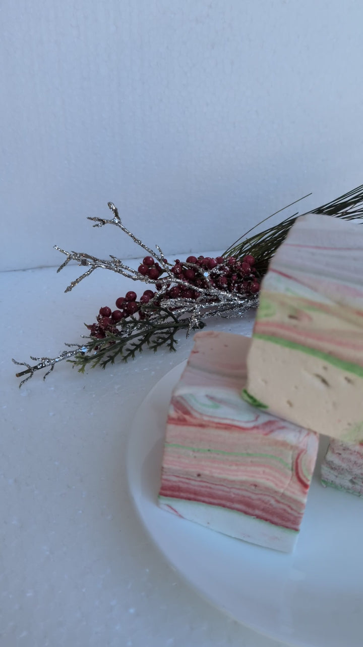 White Chocolate Peppermint Bark marshmallows by The Toasty S’more shown in motion with festive Christmas greenery, highlighting texture, sparkle, and handcrafted detail. Corn-syrup free and made with beef gelatin and organic marshmallow root for a clean-label holiday indulgence.